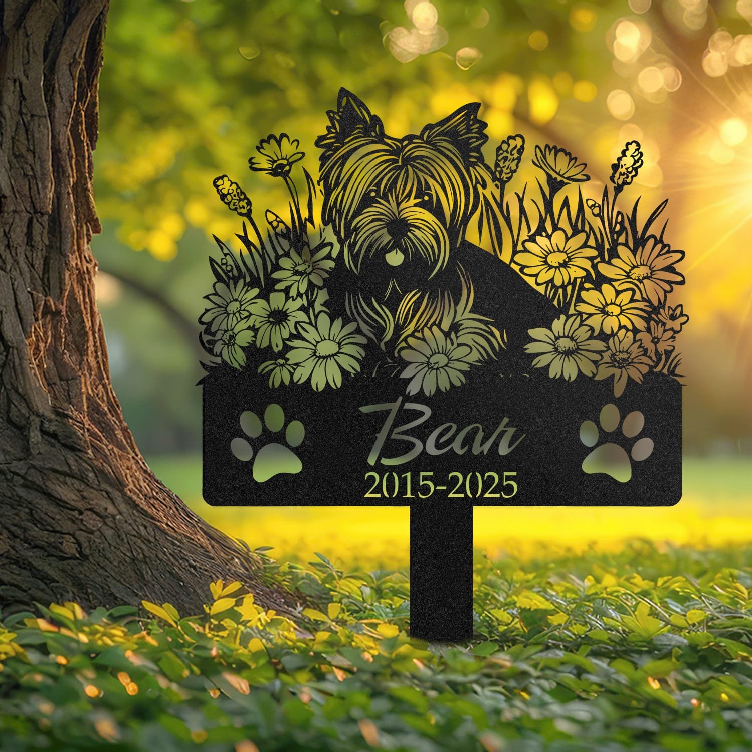 Yorkshire Terrier pet grave marker displayed outdoors in a garden setting, showing the personalized angel wings and daisy floral design in place on the stake.
