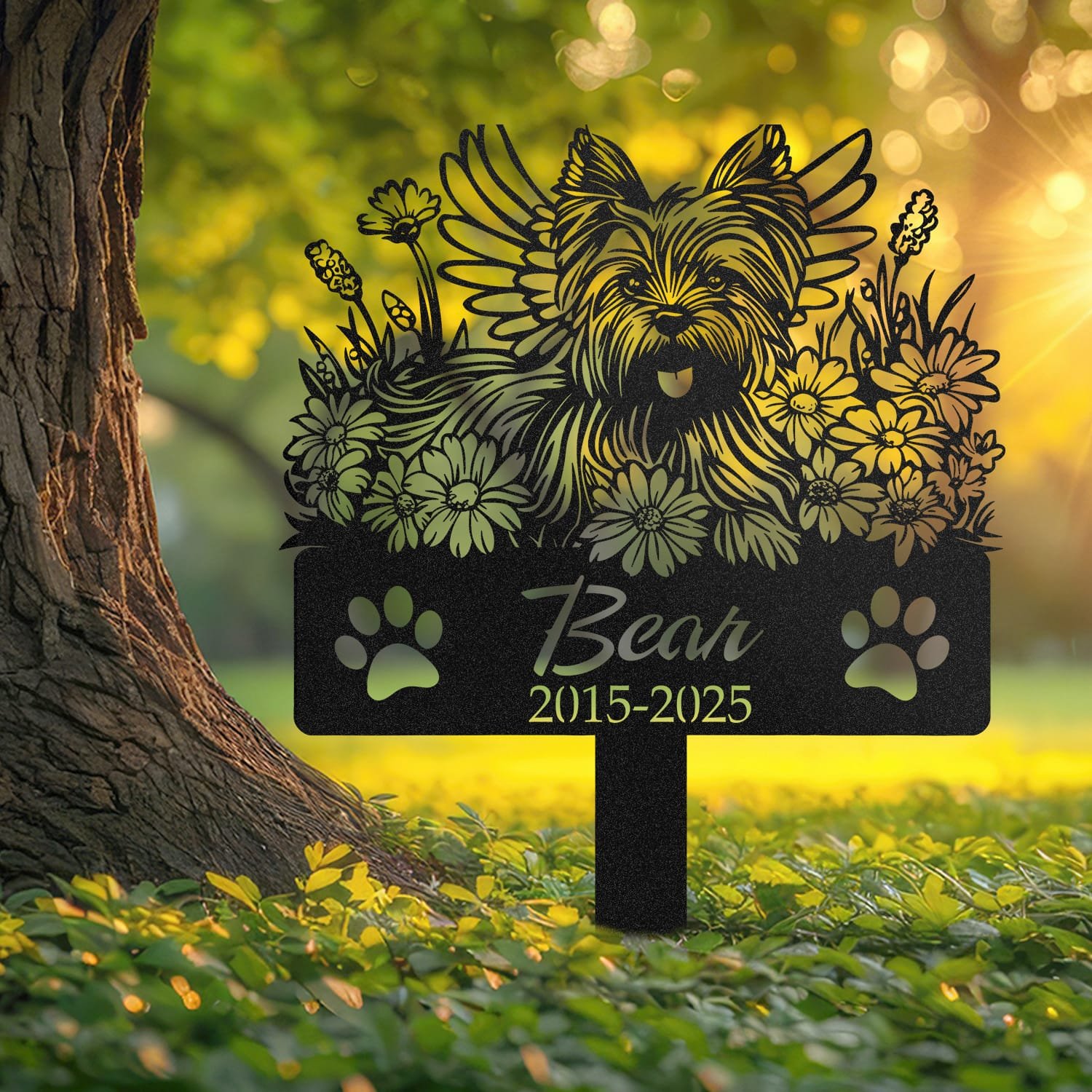 Yorkshire Terrier pet grave marker displayed outdoors in a garden setting, showing the personalized angel wings and daisy floral design in place on the stake.