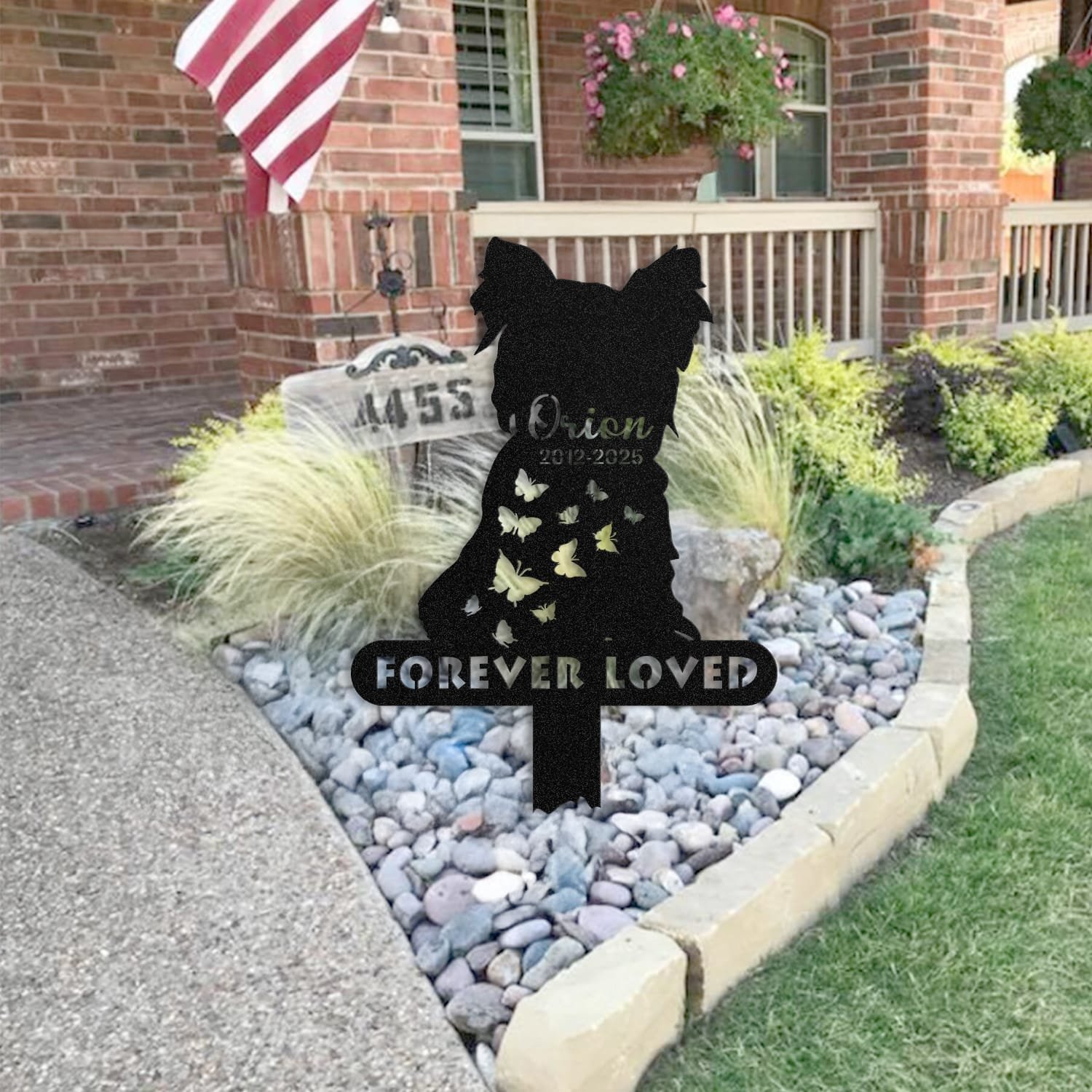 Yorkshire Terrier pet grave marker staged near a home entryway, showing the finished two-pet silhouette design with the 'Forever Loved' engraving and name plate outdoors.