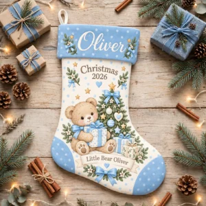 personalized blue polka teddy stocking shown laid flat on a wooden surface beside wrapped gifts and greenery